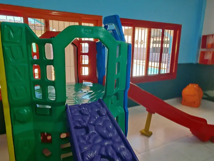 Casinha de brinquedo com escorregador na brinquedoteca