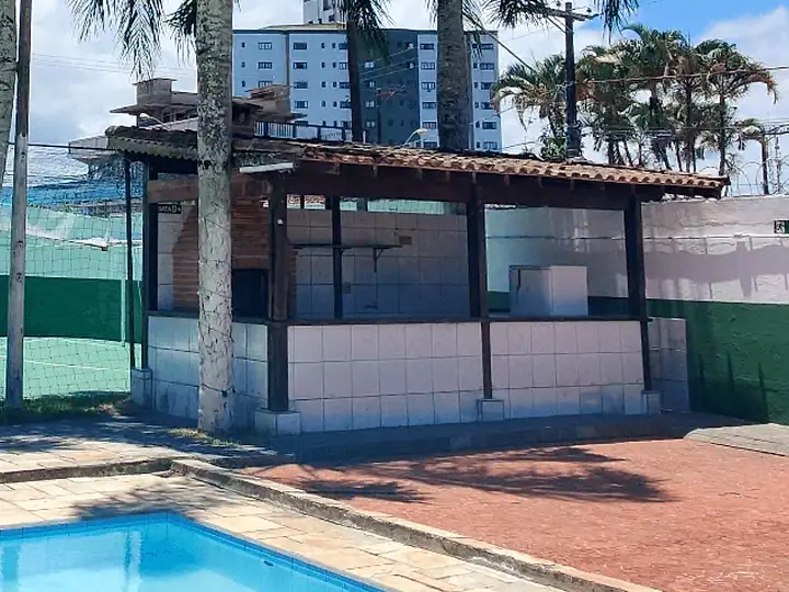 Churrasqueira coberta de tijolos ao lado da piscina infantil