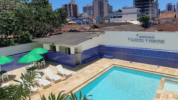 Piscina adulto e piscina infantil lado a lado, com prédios de Praia Grande ao fundo