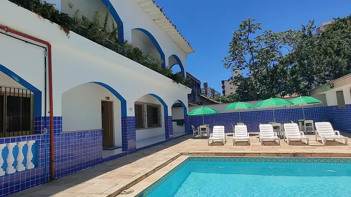 Piscina diante da varanda de arcos com azulejos azuis