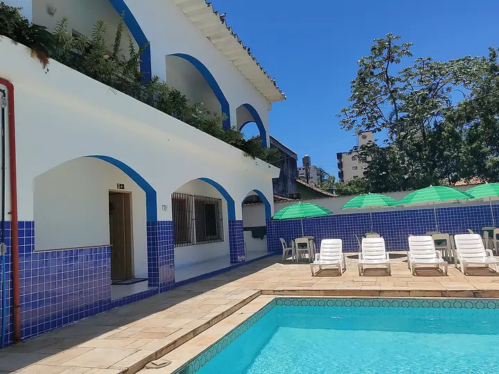 Piscina diante da varanda de arcos com azulejos azuis