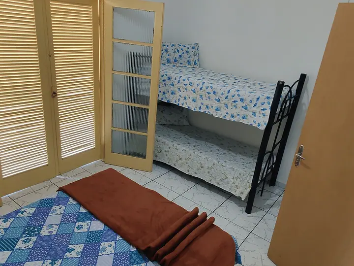 Quarto com beliche, cama e armário de portas venezianas