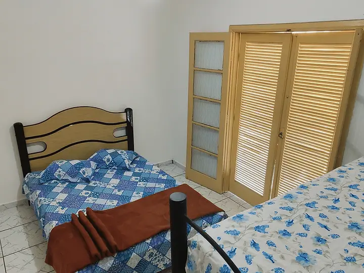 Quarto com duas camas e armário de madeira