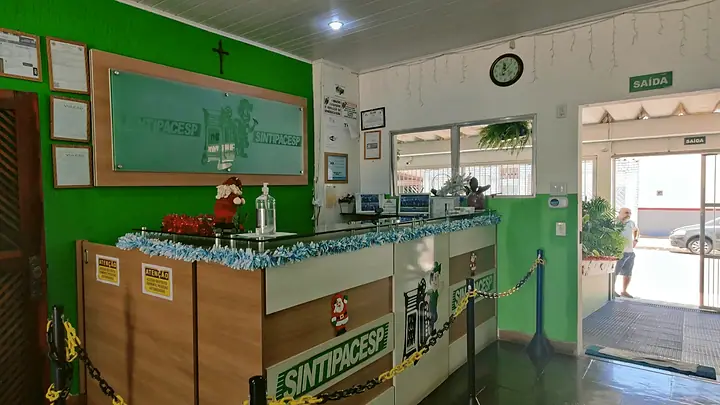 Balcão da recepção com o logo do SINTIPACESP e paredes verdes