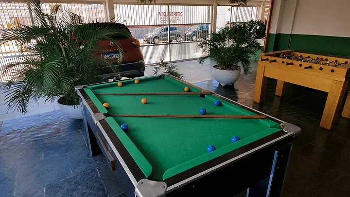Mesa de bilhar e pebolim no salão de jogos