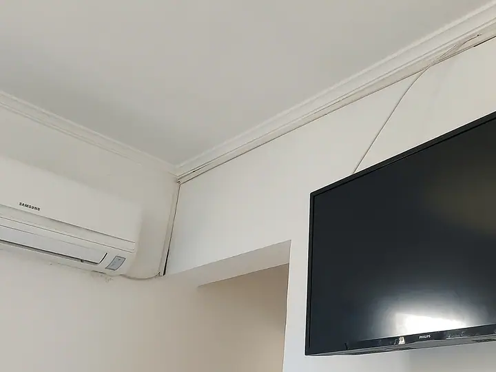 Televisão na parede e ar-condicionado num dos quartos